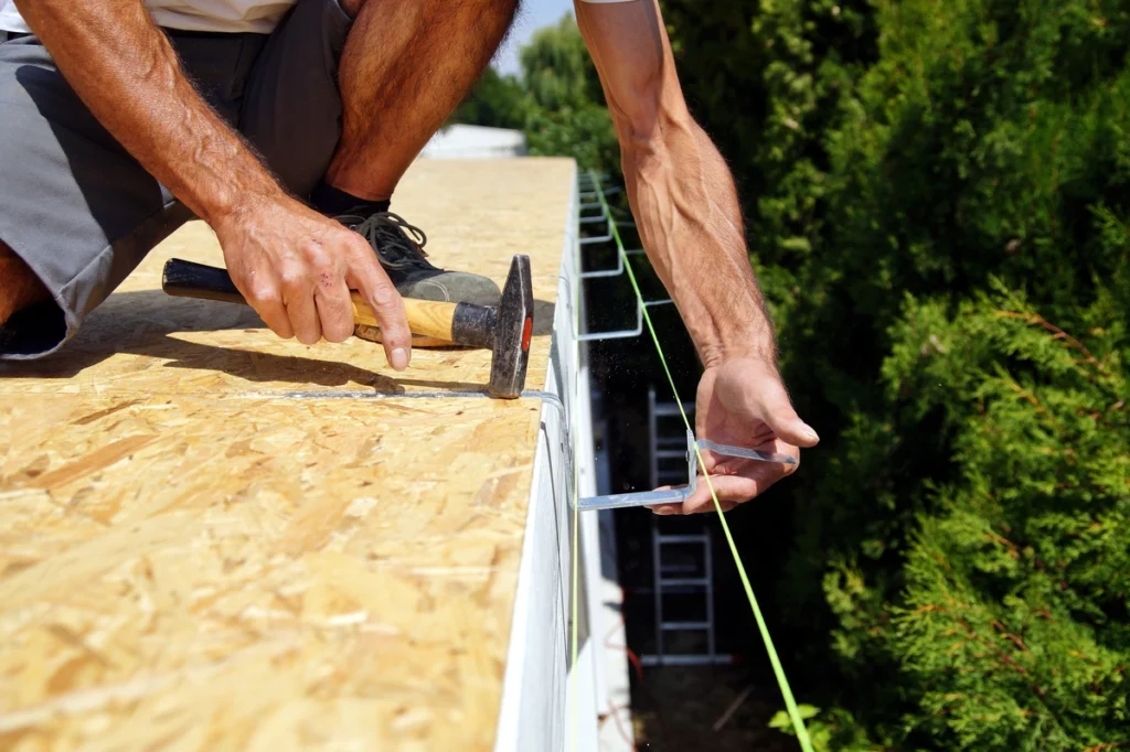 closeup of contractor installing gutters at reasonable price