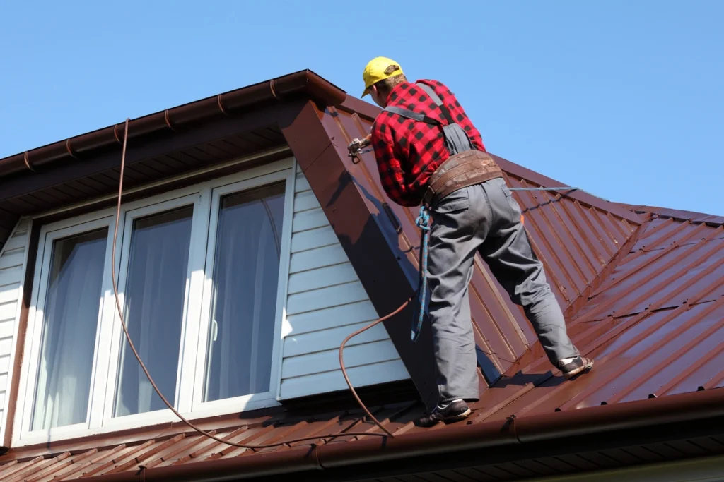 roofer on roof applying the best roof coating ever to a metal roof